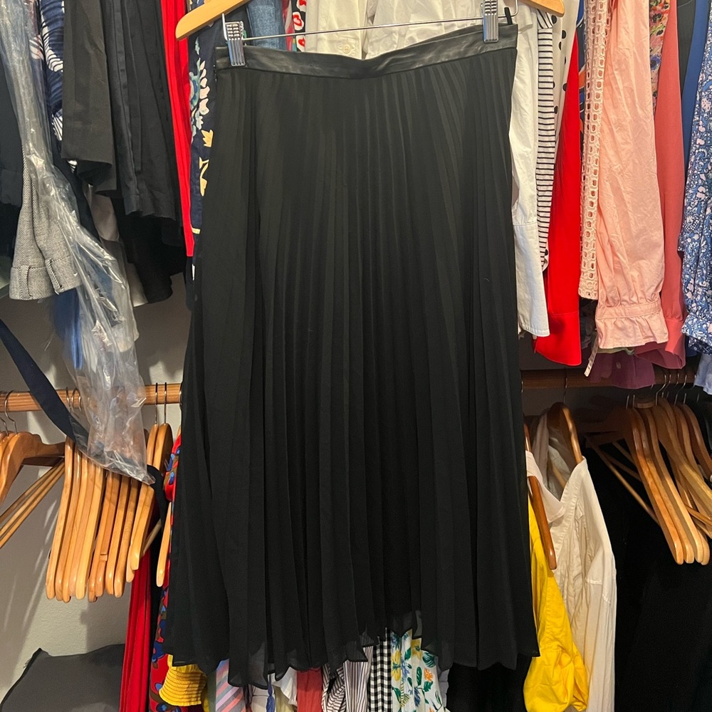 Black pleated skirt with leather trim.